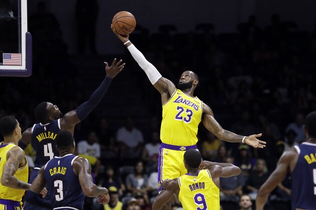 Los Angeles Lakers forward LeBron James (23) grabs a rebound over Denver Nuggets forward Paul Millsap (4) during the first half of an NBA preseason basketball game, Sunday, Sept. 30, 2018, in San Diego. (AP Photo/Gregory Bull)