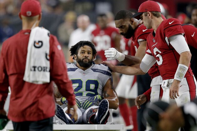 Seattle Seahawks defensive back Earl Thomas (29) is greeted by Arizona Cardinals players as he leaves the field after breaking his leg during the second half of an NFL football game, Sunday, Sept. 30, 2018, in Glendale, Ariz. The Seahawks won 20-17. (AP Photo/Ross D. Franklin)