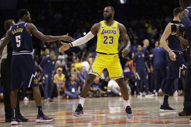 Los Angeles Lakers forward LeBron James (23) greets Denver Nuggets guard Will Barton (5) during the first half of an NBA preseason basketball game Sunday, Sept. 30, 2018, in San Diego. (AP Photo/Gregory Bull)