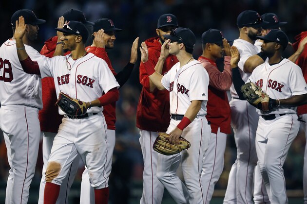 The Boston Red Sox, including from foreground left, Mookie Betts, Andrew Benintendi and Jackie Bradley Jr., celebrate after defeating the New York Mets during a baseball game in Boston, Saturday, Sept. 15, 2018. (AP Photo/Michael Dwyer)