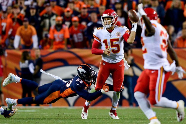 DENVER, CO - OCTOBER 1:  Quarterback Patrick Mahomes #15 of the Kansas City Chiefs throws a left-handed pass for a completion while he is hit by linebacker Von Miller #58 of the Denver Broncos in the fourth quarter of a game at Broncos Stadium at Mile High on October 1, 2018 in Denver, Colorado. (Photo by Dustin Bradford/Getty Images)