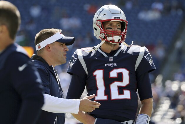 New England Patriots offensive coordinator Josh McDaniels, left, talks to quarterback Tom Brady before an NFL football game against the Miami Dolphins, Sunday, Sept. 30, 2018, in Foxborough, Mass. (AP Photo/Elise Amendola)