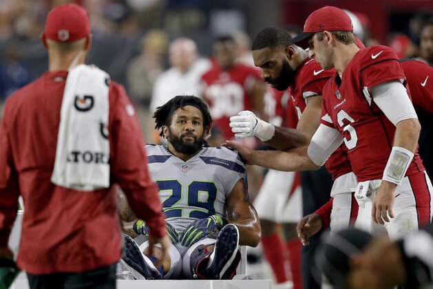 Seattle Seahawks defensive back Earl Thomas (29) is greeted by Arizona Cardinals players as he leaves the field after breaking his leg during the second half of an NFL football game, Sunday, Sept. 30, 2018, in Glendale, Ariz. The Seahawks won 20-17. (AP Photo/Ross D. Franklin)