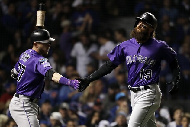Colorado Rockies' Charlie Blackmon, right, celebrates with Trevor Story after scoring on a sacrifice fly by Nolan Arenado during the first inning of the National League wild-card playoff baseball game against the Chicago Cubs, Tuesday, Oct. 2, 2018, in Chicago. (AP Photo/Nam Y. Huh)