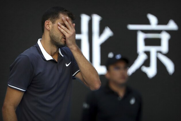 Grigor Dimitrov of Bulgaria reacts while competing against Dusan Lajovic of Serbia in their second round men's singles match in the China Open at the National Tennis Stadium in Beijing, Wednesday, Oct. 3, 2018. Background reads: