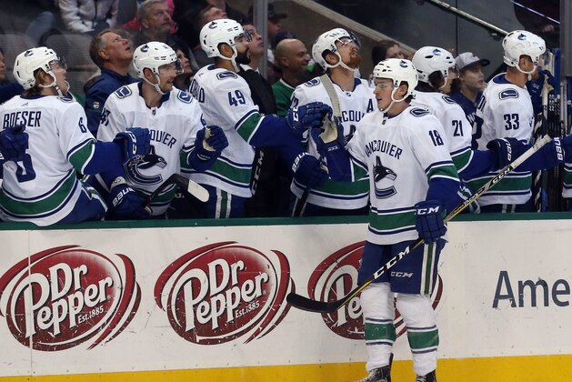 Vancouver Canucks right wing Jake Virtanen (18) celebrates a goal with his bench during the first period of an NHL hockey game against the Dallas Stars in Dallas, Sunday, Feb. 11, 2018. (AP Photo/Michael Ainsworth)