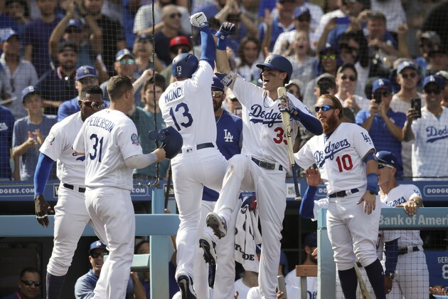 Los Angeles Dodgers' Max Muncy, center left, celebrates his two-run home run with Cody Bellinger during the fifth inning of a tiebreaker baseball game against the Colorado Rockies, Monday, Oct. 1, 2018, in Los Angeles. (AP Photo/Jae C. Hong)