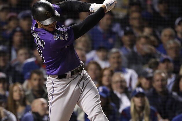 Colorado Rockies' Nolan Arenado hits a sacrifice fly against the Chicago Cubs during the first inning of the National League wild-card playoff baseball game Tuesday, Oct. 2, 2018, in Chicago. (AP Photo/Nam Y. Huh)
