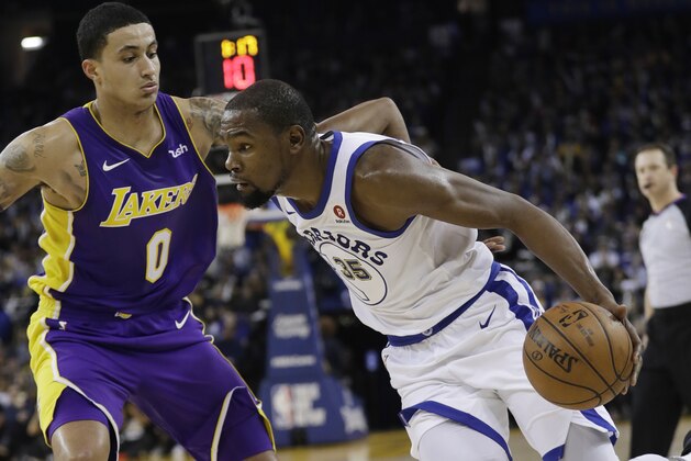 Golden State Warriors forward Kevin Durant (35) dribbles past Los Angeles Lakers forward Kyle Kuzma (0) during the second half of an NBA basketball game Friday, Dec. 22, 2017, in Oakland, Calif. (AP Photo/Marcio Jose Sanchez)