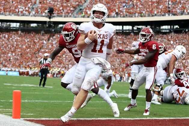 DALLAS, TX - OCTOBER 06:  Sam Ehlinger #11 of the Texas Longhorns smiles as he runs into the endzone for a touchdown against the Oklahoma Sooners in the second quarter of the 2018 AT&T Red River Showdown at Cotton Bowl on October 6, 2018 in Dallas, Texas.  (Photo by Ronald Martinez/Getty Images)