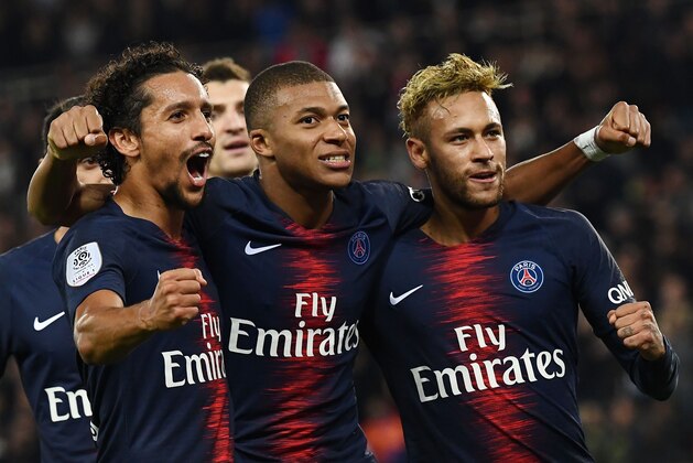 Paris Saint-Germain's French forward Kylian Mbappe (C) celebrates with Paris Saint-Germain's Brazilian forward Neymar (R) and Paris Saint-Germain's Brazilian defender Marquinhos after he scored a goal during the French L1 football match between Paris Saint-Germain (PSG) and Olympique de Lyon (OL) on October 7, 2018 at the Parc des Princes stadium in Paris. (Photo by Anne-Christine POUJOULAT / AFP)        (Photo credit should read ANNE-CHRISTINE POUJOULAT/AFP/Getty Images)