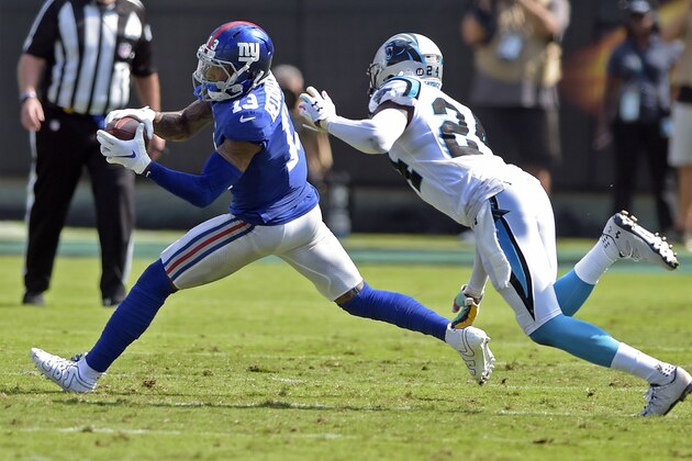 New York Giants' Odell Beckham (13) catches a pass as Carolina Panthers' James Bradberry (24) defends in the first half of an NFL football game in Charlotte, N.C., Sunday, Oct. 7, 2018. (AP Photo/Mike McCarn)