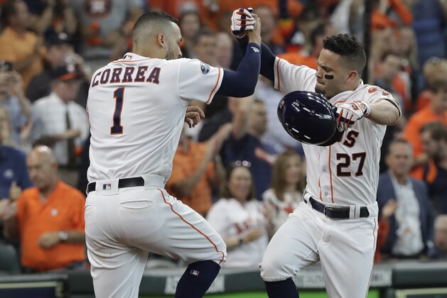 Houston Astros' Jose Altuve (27) celebrates his solo home run with teammate Carlos Correa (1) during the fifth inning in Game 1 of an American League Division Series baseball game against the Cleveland Indians, Friday, Oct. 5, 2018, in Houston. (AP Photo/David J. Phillip)