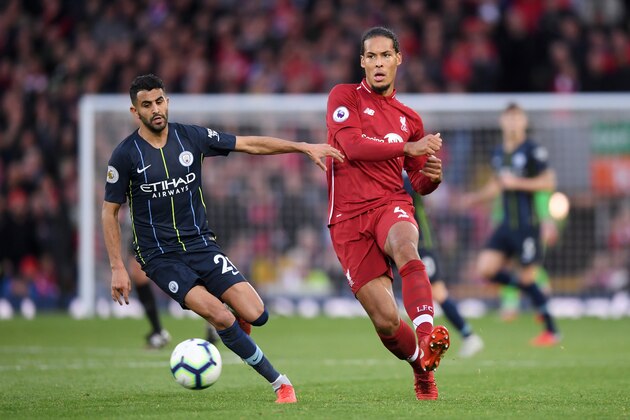 LIVERPOOL, ENGLAND - OCTOBER 07:  Virgil van Dijk of Liverpool passes the ball under pressure from Riyad Mahrez of Manchester City during the Premier League match between Liverpool FC and Manchester City at Anfield on October 7, 2018 in Liverpool, United Kingdom.  (Photo by Laurence Griffiths/Getty Images)