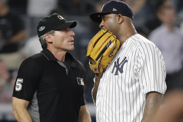 New York Yankees starting pitcher CC Sabathia talks with home plate umpire Angel Hernandez (5) at the end of the top of the first inning of Game 4 of baseball's American League Division Series against the Boston Red Sox, Tuesday, Oct. 9, 2018, in New York. (AP Photo/Frank Franklin II)