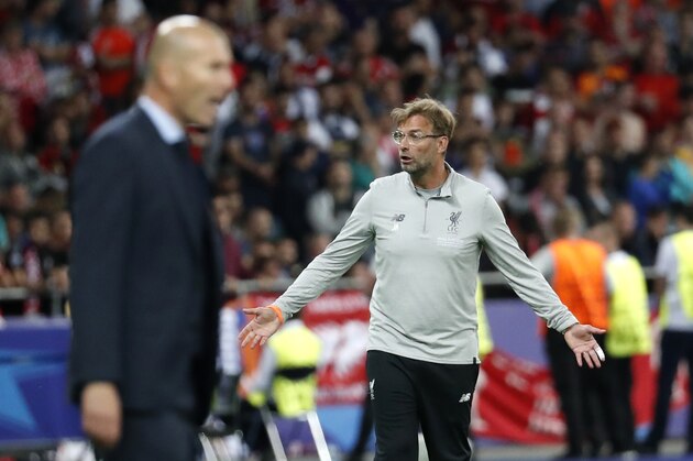 Liverpool coach Jurgen Klopp gestures next to Real Madrid coach Zinedine Zidane, left, during the Champions League Final soccer match between Real Madrid and Liverpool at the Olimpiyskiy Stadium in Kiev, Ukraine, Saturday, May 26, 2018. (AP Photo/Pavel Golovkin)