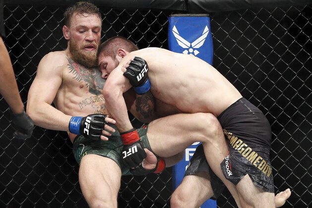 Khabib Nurmagomedov, right, tries to take down Conor McGregor during a lightweight title mixed martial arts bout at UFC 229 in Las Vegas, Saturday, Oct. 6, 2018. (AP Photo/John Locher)