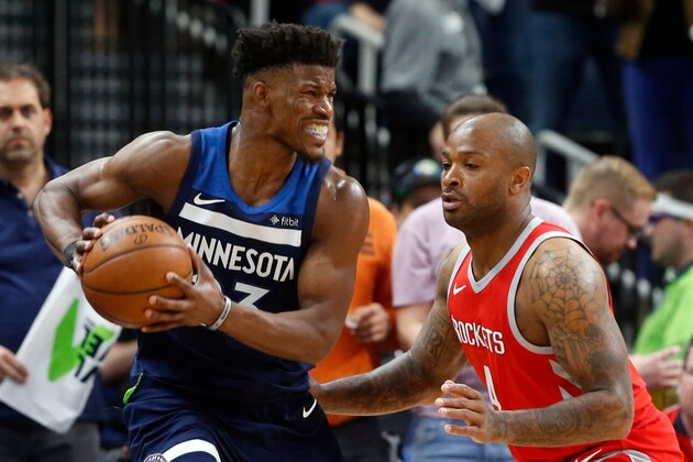 Minnesota Timberwolves' Jimmy Butler, left, keeps the ball close as Houston Rockets' PJ Tucker defends during the second half of Game 3 in an NBA basketball first-round playoff series Saturday, April 21, 2018, in Minneapolis. (AP Photo/Jim Mone)