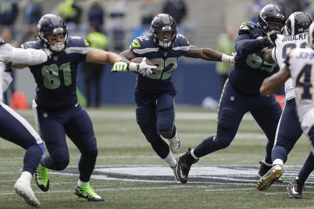 SEATTLE, WA - OCTOBER 07: Running back Chris Carson #32 of the Seattle Seahawks rushes the ball as tight end Nick Vannett #81 of the Seattle Seahawks and offensive lineman Germain Ifedi #65 of the Seattle Seahawks block during a game at CenturyLink Field on October 7, 2018 in Seattle, Washington. The Rams won the game 33-31. (Photo by Stephen Brashear/Getty Images)
