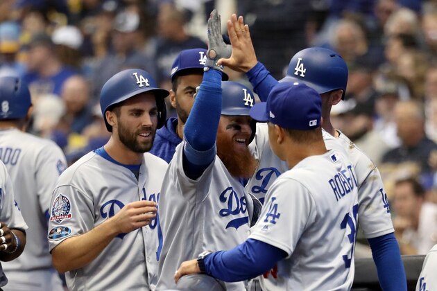MILWAUKEE, WI - OCTOBER 13:  Justin Turner #10 of the Los Angeles Dodgers celebrates with his teammates after hitting a two run home run against Jeremy Jeffress #32 of the Milwaukee Brewers during the eighth inning in Game Two of the National League Championship Series at Miller Park on October 13, 2018 in Milwaukee, Wisconsin.  (Photo by Rob Carr/Getty Images)