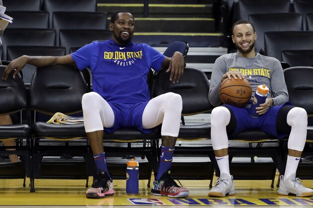 Golden State Warriors' Kevin Durant, left, and Stephen Curry smile as they take a break during an NBA basketball practice, Wednesday, May 30, 2018, in Oakland, Calif. The Warriors face the Cleveland Cavaliers in Game 1 of the NBA Finals on Thursday in Oakland. (AP Photo/Marcio Jose Sanchez)