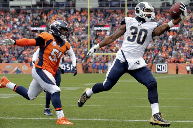 Los Angeles Rams running back Todd Gurley (30) scores a touchdown as Denver Broncos linebacker Todd Davis (51) defends during the first half of an NFL football game, Sunday, Oct. 14, 2018, in Denver. (AP Photo/Joe Mahoney)