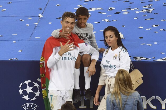 Real Madrid's Portuguese forward Cristiano Ronaldo poses with his girlfriend Georgina Rodriguez and his son Cristiano Jr after his team won the UEFA Champions League final football match between Liverpool and Real Madrid at the Olympic Stadium in Kiev, Ukraine on May 26, 2018. (Photo by Sergei SUPINSKY / AFP)        (Photo credit should read SERGEI SUPINSKY/AFP/Getty Images)
