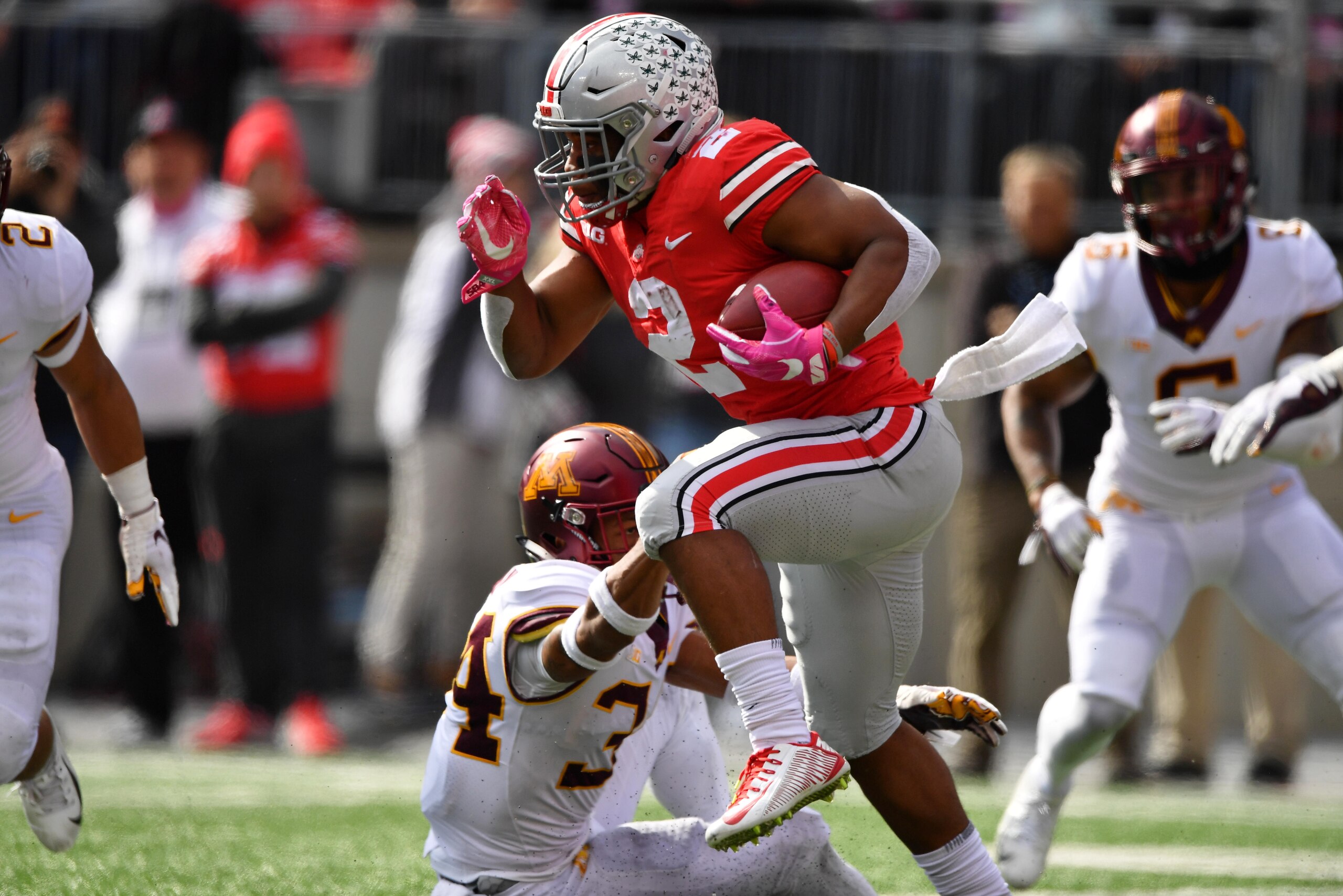 COLUMBUS, OH - OCTOBER 13:  J.K. Dobbins #2 of the Ohio State Buckeyes runs by Antonio Shenault #34 of the Minnesota Golden Gophers to pick up a first down in the fourth quarter at Ohio Stadium on October 13, 2018 in Columbus, Ohio. Ohio State defeated Minnesota 30-14.  (Photo by Jamie Sabau/Getty Images)