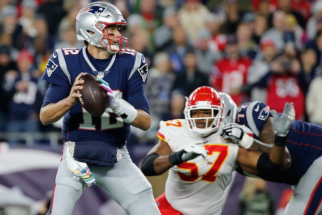 FOXBOROUGH, MA - OCTOBER 14: Tom Brady #12 of the New England Patriots feels the pressure of Breeland Speaks #57 of the Kansas City Chiefs in the fourth quarter at Gillette Stadium on October 14, 2018 in Foxborough, Massachusetts. Brady ran the ball in to the end zone for a touchdown on the play.(Photo by Jim Rogash/Getty Images)