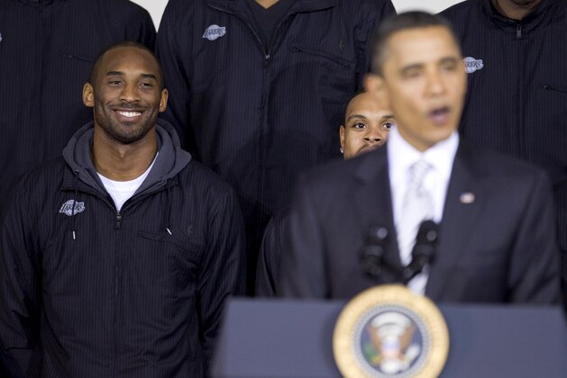 Los Angeles Lakers guard Kobe Bryant smiles at left as President Barack Obama speaks during an event to honor the NBA basketball champion Los Angeles Lakers, in Washington, Monday, Dec. 13, 2010, at the Boys and Girls Club of Greater Washington, in Washington.  (AP Photo/Evan Vucci)