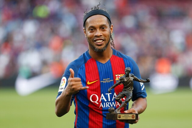 Former Barcelona's Brazilian forward Ronaldinho poses with the trophy for the best player after a charity football match between Barcelona Legends vs Manchester United Legends at the Camp Nou stadium in Barcelona on June 30, 2017. / AFP PHOTO / Pau Barrena        (Photo credit should read PAU BARRENA/AFP/Getty Images)
