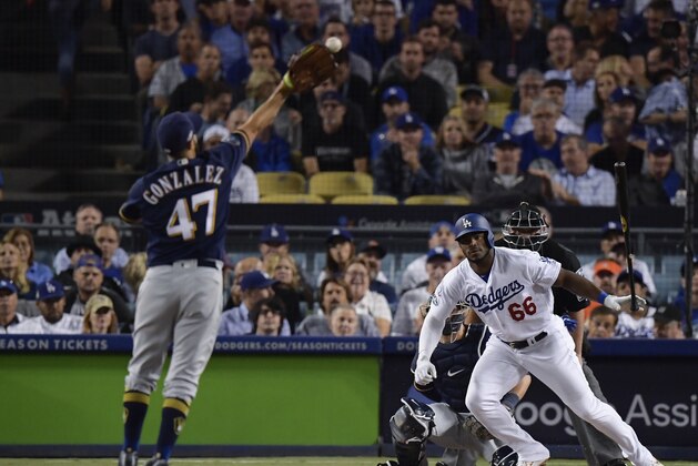 Milwaukee Brewers starting pitcher Gio Gonzalez twists his ankle going for a ball hit by Los Angeles Dodgers' Yasiel Puig during the second inning of Game 4 of the National League Championship Series baseball game Tuesday, Oct. 16, 2018, in Los Angeles. (AP Photo/Mark J. Terrill)