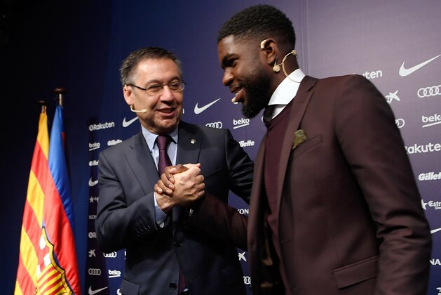 French football player Samuel Umtiti (R) and the president of FC Barcelona Josep Maria Bartomeu pose during a press conference after the player's renewal with the club at the Camp Nou stadium in Barcelona on June 4, 2018. (Photo by LLUIS GENE / AFP)        (Photo credit should read LLUIS GENE/AFP/Getty Images)