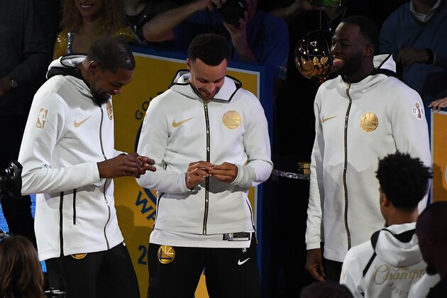 OAKLAND, CA - OCTOBER 16: Kevin Durant #35, Stephen Curry #30 and Draymond Green #23 of the Golden State Warriors laugh during the 2017-2018 Championship ring ceremony prior to their game against the Oklahoma City Thunder at ORACLE Arena on October 16, 2018 in Oakland, California. NOTE TO USER: User expressly acknowledges and agrees that, by downloading and or using this photograph, User is consenting to the terms and conditions of the Getty Images License Agreement. (Photo by Robert Reiners/Getty Images) OAKLAND, CA - OCTOBER 16: Kevin Durant #35, Stephen Curry #30 and Draymond Green #23 of the Golden State Warriors laugh during the 2017-2018 Championship ring ceremony prior to their game against the Oklahoma City Thunder at ORACLE Arena on October 16, 2018 in Oakland, California. NOTE TO USER: User expressly acknowledges and agrees that, by downloading and or using this photograph, User is consenting to the terms and conditions of the Getty Images License Agreement. (Photo by Robert Reiners/Getty Images)