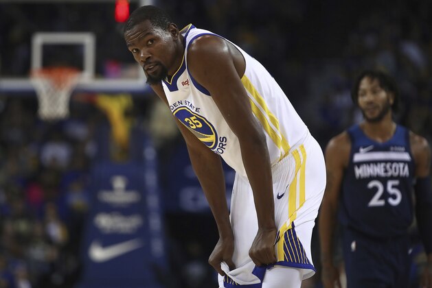 Golden State Warriors' Kevin Durant, left, and Minnesota Timberwolves' Derrick Rose (25) wait during a timeout in the first half of an NBA preseason basketball game Saturday, Sept. 29, 2018, in Oakland, Calif. (AP Photo/Ben Margot)