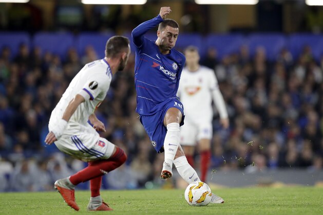 Chelsea's Eden Hazard shoots the ball past Vidi's Attila Fiola, left, during the Europa League group L soccer match between Chelsea and Vidi FC at Stamford Bridge stadium in London, Thursday, Oct. 4, 2018. (AP Photo/Matt Dunham)