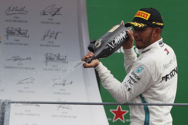 Mercedes driver Lewis Hamilton of Britain celebrates on the podium after winning the Formula One Italy Grand Prix at the Monza racetrack, in Monza, Italy, Sunday, Sept. 2, 2018. (AP Photo/Antonio Calanni)