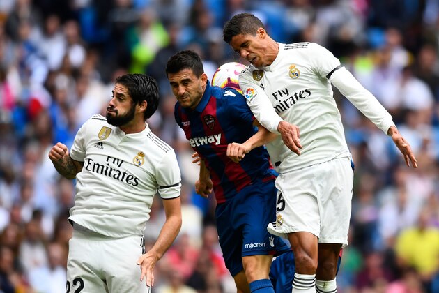 (FromL) Real Madrid's Spanish midfielder Isco, Levante's Spanish defender Sergio Postigo and Real Madrid's French defender Raphael Varane jump for the ball during the Spanish league football match Real Madrid CF against Levante UD at the Santiago Bernabeu stadium in Madrid on October 20, 2018. (Photo by GABRIEL BOUYS / AFP)        (Photo credit should read GABRIEL BOUYS/AFP/Getty Images)