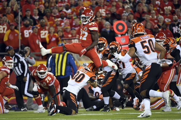 Kansas City Chiefs running back Kareem Hunt (27) vaults over Cincinnati Bengals safety Jessie Bates (30) during the first half of an NFL football game in Kansas City, Mo., Sunday, Oct. 21, 2018. (AP Photo/Reed Hoffmann)