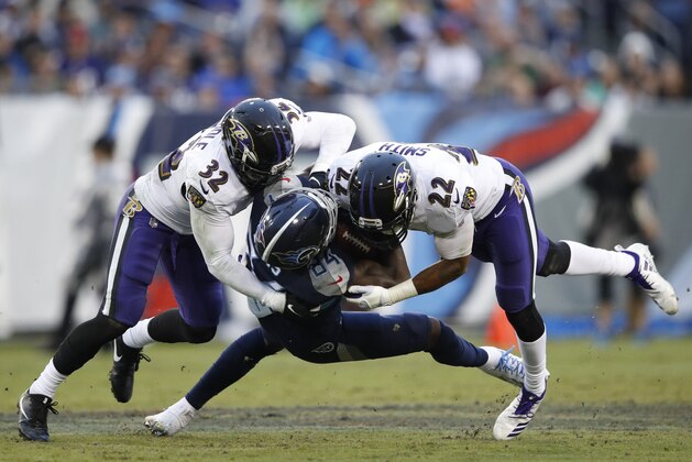 NASHVILLE, TN - OCTOBER 14: Corey Davis #84 of the Tennessee Titans is tackled by Eric Weddle #32 of the Baltimore Ravens and Jimmy Smith #22 during the third quarter at Nissan Stadium on October 14, 2018 in Nashville, Tennessee. (Photo by Joe Robbins/Getty Images)