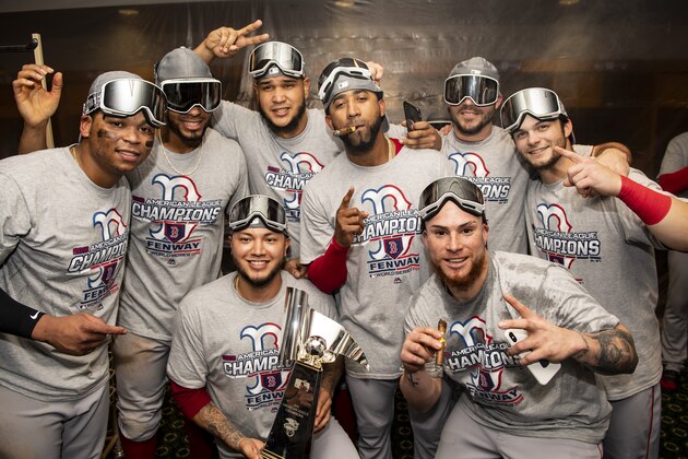 HOUSTON, TX - OCTOBER 18:Rafael Devers #11, Xander Bogaerts #2, Hector Velazquez #76, Eduardo Rodriguez #52, Eduardo Nunez #36, Steve Pearce #25, Christian Vazquez #7, and Andrew Benintendi #16 of the Boston Red Sox pose for a photograph with the American League Championship Series trophy in the clubhouse after clinching the American League Championship Series in game five against the Houston Astros on October 18, 2018 at Minute Maid Park in Houston, Texas. (Photo by Billie Weiss/Boston Red Sox/Getty Images)