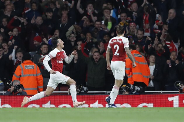 Arsenal's Mesut Ozil, left, celebrates after scoring his side's first goal of the game during the English Premier League soccer match between Arsenal and Leicester City at the Emirates stadium in London, Monday, Oct. 22, 2018. (AP Photo/Alastair Grant)