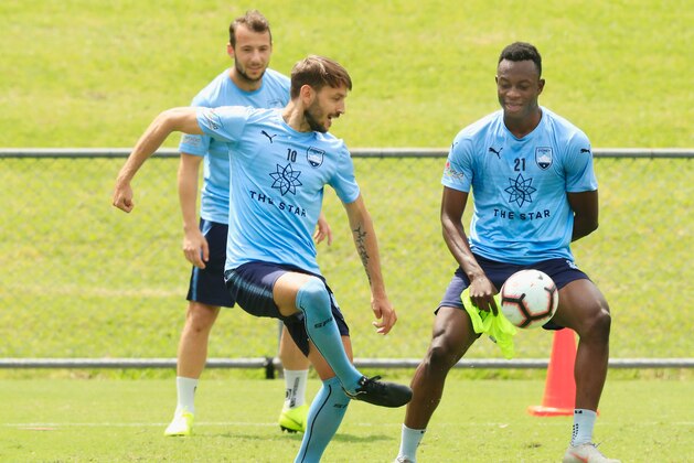 SYDNEY, AUSTRALIA - OCTOBER 22: Milos Ninkovoic of Sydney FC passes the ball as Charles Lokolingoy (R) looks on during a Sydney FC A-League media opportunity at Macquarie Uni on October 22, 2018 in Sydney, Australia.  (Photo by Mark Evans/Getty Images)