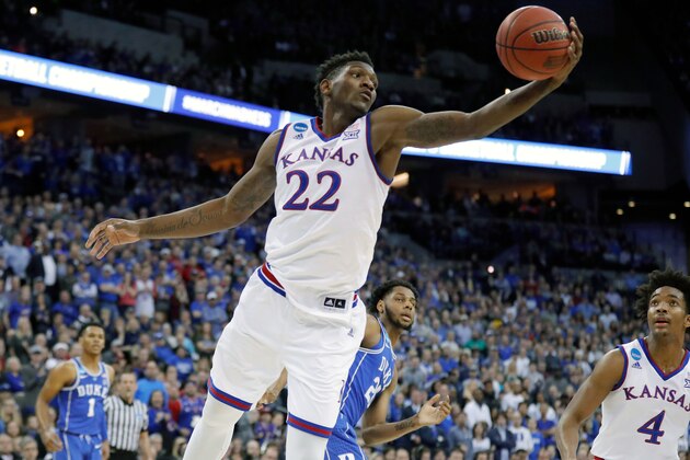 FILE - In this March 25, 2018, file photo, Kansas' Silvio De Sousa reaches for a rebound during the first half of a regional final game against Duke in the NCAA men's college basketball tournament, in Omaha, Neb. Kansas and North Carolina State are the latest schools to be swept up in a bribery scandal involving college basketball. A rewritten indictment released Tuesday, April 10, 2018, in New York alleges that an Adidas representative, who no longer works for the company, arranged for payments to parents of athletes willing to commit to the schools. No players are directly named, but specific details make clear the indictment is describing former North Carolina State star Dennis Smith Jr. and Kansas player Silvio De Sousa.(AP Photo/Charlie Neibergall, File)
