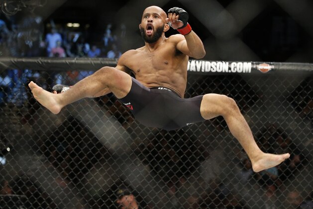 Demetrious Johnson celebrates after defeating Henry Cejudo in a flyweight championship mixed martial arts bout at UFC 197, Saturday, April 23, 2016, in Las Vegas. (AP Photo/John Locher)