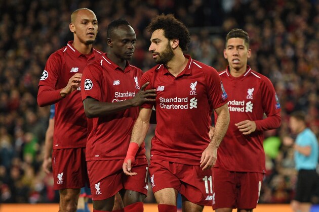 Liverpool's Egyptian midfielder Mohamed Salah (2nd R) celebrates with Liverpool's Senegalese striker Sadio Mane (2nd L) and Liverpool's Brazilian midfielder Fabinho (L) after scoring their third goal from the penalty spot during the UEFA Champions League group C football match between Liverpool and Red Star Belgrade at Anfield in Liverpool, north west England on October 24, 2018. (Photo by Oli SCARFF / AFP)        (Photo credit should read OLI SCARFF/AFP/Getty Images)
