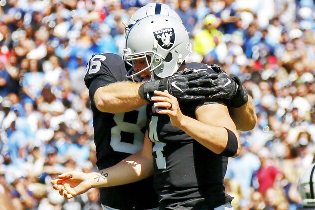 NASHVILLE, TN- SEPTEMBER 10: Quarterback Derek Carr  #4 of the Oakland Raiders celebrates with teammate Tight End Lee Smith  #86 against the Tennessee Titans in the first quarter at Nissan Stadium on September 10, 2017 In Nashville, Tennessee. (Photo by Frederick Breedon/Getty Images)