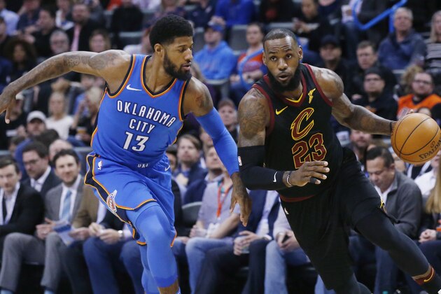 Cleveland Cavaliers forward LeBron James (23) drives past Oklahoma City Thunder forward Paul George (13) during the first half of an NBA basketball game in Oklahoma City, Tuesday, Feb. 13, 2018. (AP Photo/Sue Ogrocki)