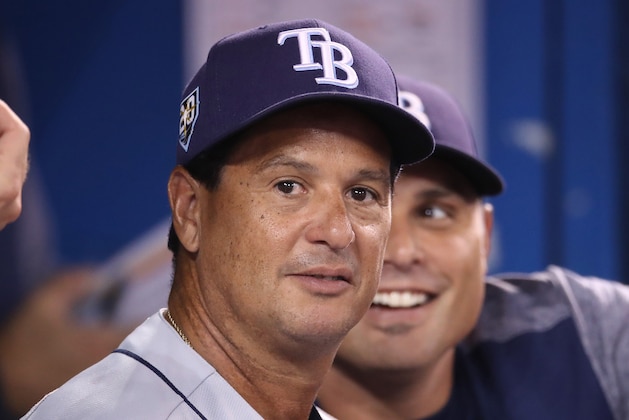 TORONTO, ON - SEPTEMBER 5: Bench coach Charlie Montoyo #25 of the Tampa Bay Rays looks on from the dugout as manager Kevin Cash #16 smiles behind him during MLB game action against the Toronto Blue Jays at Rogers Centre on September 5, 2018 in Toronto, Canada. (Photo by Tom Szczerbowski/Getty Images)