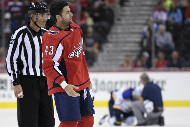 FILE - In this Sept. 30, 2018, file photo, Washington Capitals right wing Tom Wilson (43) is escorted by an official off the ice after he checked St. Louis Blues center Oskar Sundqvist, on ice at back center, during the second period of an NHL preseason hockey game, in Washington. Wilson has been suspended 20 games by the NHL for a blindside hit to the head of an opponent during a preseason game. Wilson's punishment was announced Wednesday, Oct. 3, 2018, just hours before the reigning Stanley Cup champion Capitals were to raise their banner and open their title defense by hosting the Boston Bruins to begin the regular season. (AP Photo/Nick Wass, File)